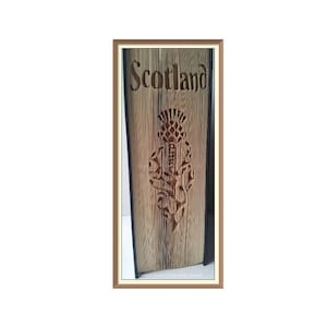 Peut inclure: Gros plan d'un livre en bois avec le mot "Scotland" gravé sur la couverture. Le livre est décoré d'un chardon gravé, la fleur nationale de l'Écosse.