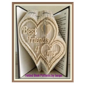 Könnte beinhalten: Eine Buchkunstskulptur aus zwei ineinander verschlungenen Herzen, die aus den Seiten eines Buches gefertigt sind. Die Herzen sind gefaltet, um einen 3D-Effekt zu erzeugen, und die Worte "Best Friends 4 Ever" sind auf die Herzen geschrieben.