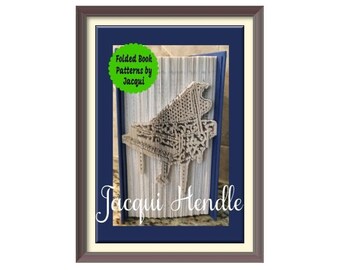 May include: A framed image of a book art sculpture of a piano. The book art is made from the pages of a book that have been folded and layered to create the shape of a piano. The image is titled "Folded Book Patterns by Jacqui" and "Jacqui Hendle".