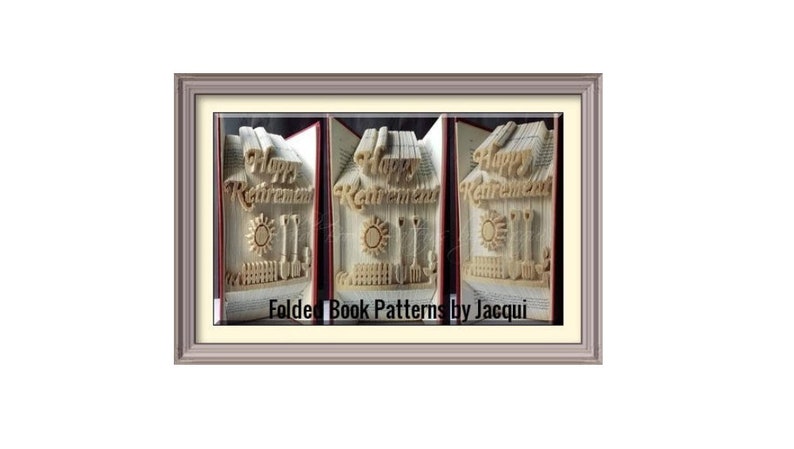 May include: A book art sculpture of a house with the words "Happy Retirement" folded into the pages. The house has a sun and garden tools. The book is framed in a light brown frame. The text "Folded Book Patterns by Jacqui" is at the bottom of the frame.