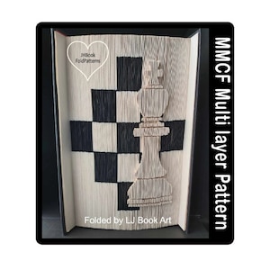 Op de afbeelding: Een gevouwen boekkunstwerk met een schaakkoning en een dambordpatroon in zwart en wit. Het boek is open, met de pagina's gevouwen om het ontwerp te creëren. Tekst aan de zijkant luidt "MMCF Multi layer Pattern".