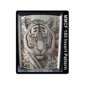 Puede incluir: Una cara de tigre marrón y blanco está doblada de papel en un estilo de arte de libro. El libro se titula "MMCF 180 Invert Pattern" y está doblado por LJ Book Art.
