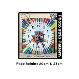 May include: A colourful clock with a design of coloured pencils around the face. The clock face is white with black numbers. The clock is 20 cm and 23 cm in height.