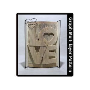 May include: A book folded into the shape of the word "LOVE" with a heart in the center. The book is on a black stand. The text "JHBookFold Patterns" is in a heart shape in the top left corner. The text "Graph Multilayer Pattern" is on the right side of the image.