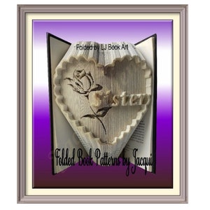 May include: A book art sculpture of a heart with a rose and the word "Sister" folded into the pages. The book is framed and has a purple and white gradient background.