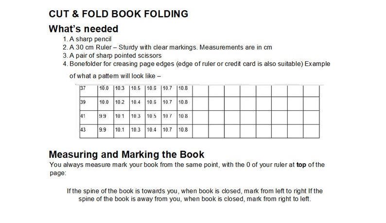 May include: A black and white diagram showing how to measure and mark a book for folding. The diagram includes a grid with measurements in centimeters and instructions for marking the book based on the spine's position.
