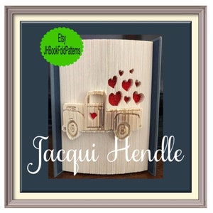 May include: A wooden book folding pattern of a red pickup truck carrying a load of red hearts. The pattern is titled "Jacqui Hendle" and includes the Etsy shop name "JHBookFoldPatterns".