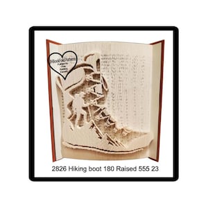 May include: A book art sculpture depicting a hiking boot, cut from the pages of a book. The design includes a hiker and mountain scene. The text "2826 Hiking boot 180 Raised 555 23" is visible. The book is open.