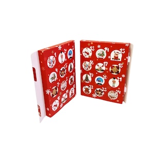 May include: Red cardboard advent calendar with 24 numbered doors, each with a different Christmas-themed image. The calendar is folded in half, showing the front and back sides.
