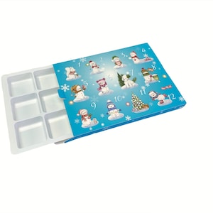 May include: A blue and white cardboard box with a snowman theme. The box has 12 numbered compartments, each with a different snowman illustration. The box is open, revealing a white plastic tray with 8 compartments.