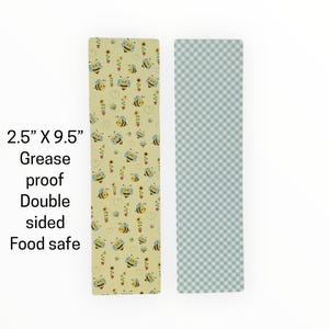May include: Two rectangular food-safe sheets, 2.5" x 9.5", with different patterns. One features bees, sunflowers, and hearts on a yellow background. The other has a light blue and white checkered pattern. The text reads "Grease proof Double sided Food safe."