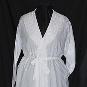 May include: A white long-sleeved robe with a white embroidered collar and a tie belt.