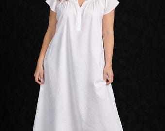 May include: A white nightgown with short sleeves and a V-neckline. The dress has a buttoned placket and a flowing skirt. The model is wearing the nightgown against a black background.