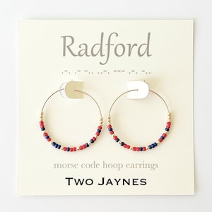 May include: Gold hoop earrings with red, gold, and blue beads. The earrings are displayed on a white card with the text "Radford" and "morse code hoop earrings" and the brand name "TWO JAYNES".