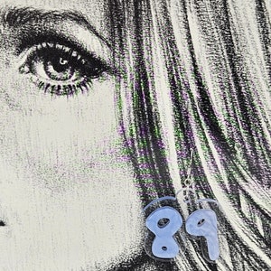 Pu&ograve; includere: Un paio di orecchini in acrilico blu a forma dei numeri 8 e 9. Gli orecchini sono appesi a ganci argentati.