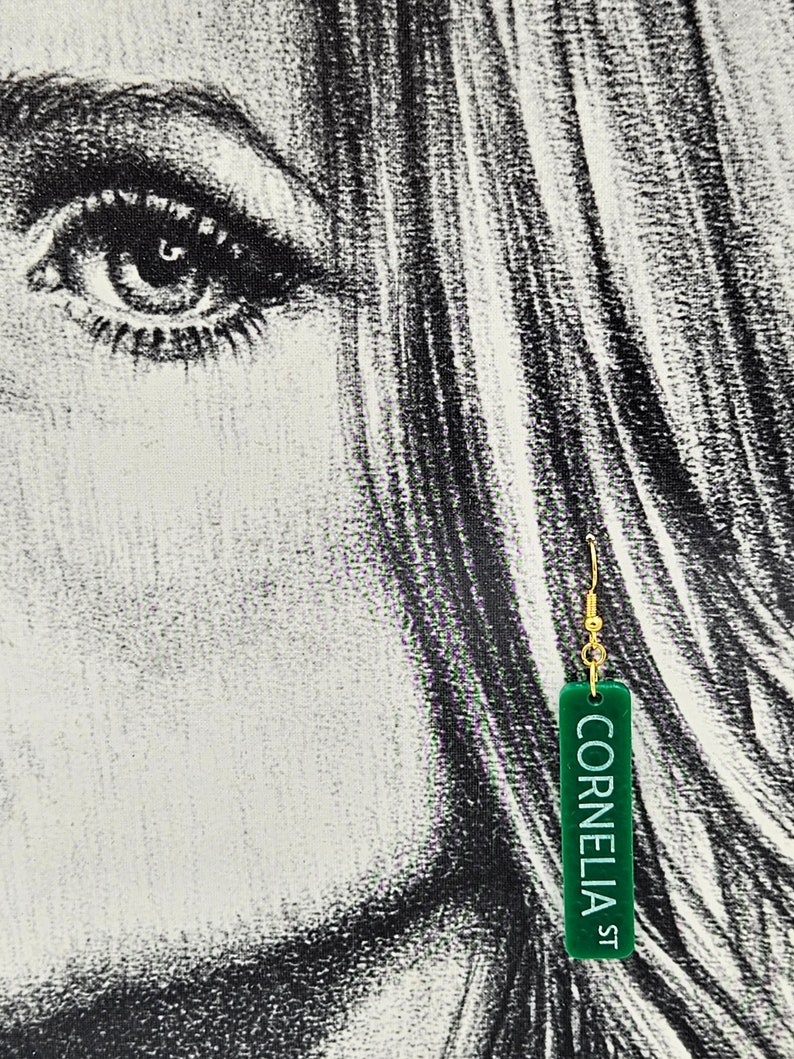 Puede incluir: Pendiente rectangular verde con gancho dorado y el texto "Cornelia St" en blanco.
