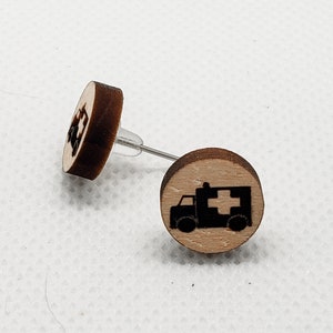 May include: A pair of wooden earrings with a black and white image of an ambulance on each earring.
