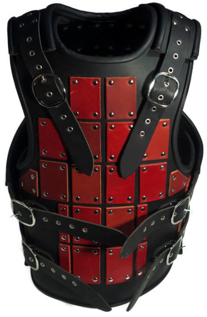 May include: A black leather armor vest with red leather plates and metal rivets. The vest has straps and buckles for adjusting the fit.