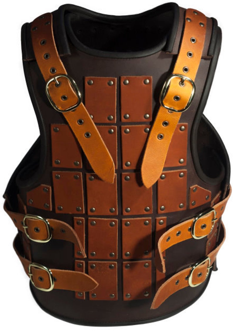 May include: A brown leather armor vest with a decorative design of square panels and metal rivets. The vest has adjustable straps with buckles.