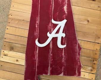 Crimson colored state of Alabama wood pallet sign; White Alabama "A" logo in the center. Roll Tide.
