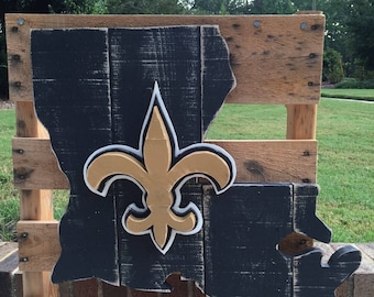 Logotipo de los New Orleans Saints con la flor de lis en un cartel de madera del estado de Luisiana