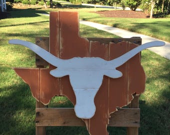 Letrero de madera color naranja quemado del estado de Texas con un logotipo de Longhorn blanco de gran tamaño en el centro.