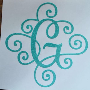 May include: A teal glitter monogram letter "G" with decorative swirls. The letter is centered on a white background. The HDG Designs logo is in the upper right corner.