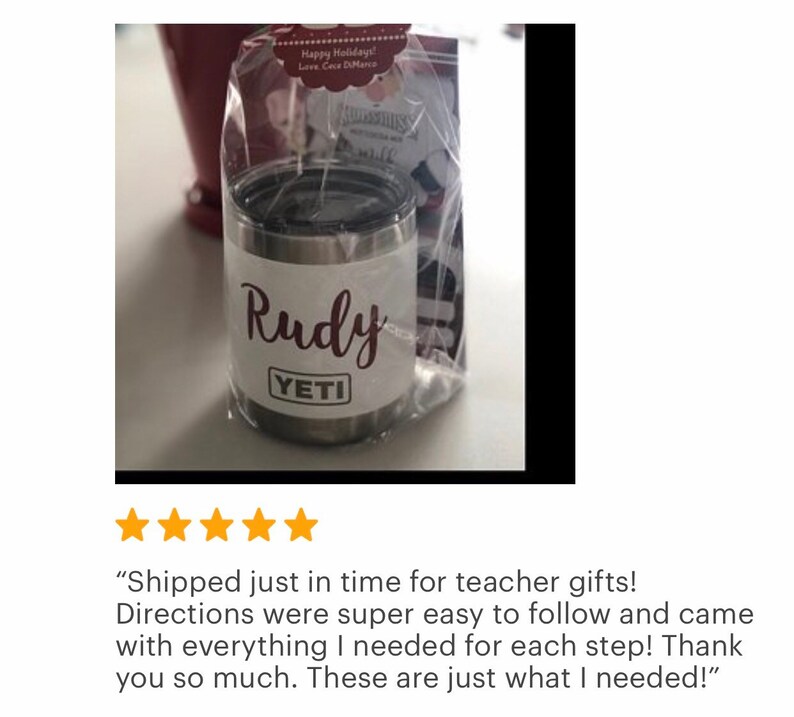 May include: A stainless steel Yeti tumbler with a black lid, personalized with the name "Rudy" in a cursive font. The tumbler is packaged in a clear cellophane bag with a gift tag. The Yeti logo is visible.