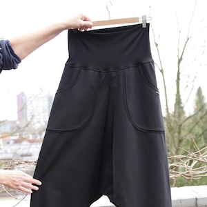 May include: Black high-waisted trousers with large pockets and a loose, flowing fit.