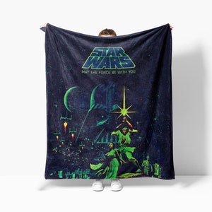 a person holding a star wars towel in front of a white wall