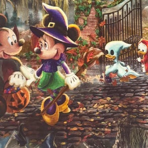 May include: A colorful Halloween-themed fabric featuring Mickey and Minnie Mouse in costumes, along with other Disney characters. The scene includes a cobblestone path, a wrought-iron gate, and autumn foliage, creating a festive atmosphere.