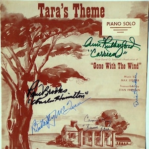 Puede incluir: Una portada de partitura vintage para "Tara's Theme" de la película "Lo que el viento se llevó". La portada presenta una ilustración de acuarela de una casa y un árbol con firmas de varios actores y actrices, incluyendo Olivia de Havilland, Ann Rutherford y Butterfly McQueen.