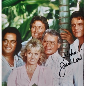 May include: A group of five people, including Jack Lord, pose for a photo. Lord is wearing a white shirt and has signed the photo "Aloha! Jack Lord".