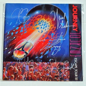 Könnte beinhalten: Ein Vinyl-Schallplattencover der Band Journey. Das Cover-Artwork zeigt ein stilisiertes Bild eines Raumschiffs, das über einen blauen und roten Hintergrund zieht. Der Albumtitel lautet "Escape Tour '81". Das Cover ist von den Bandmitgliedern signiert.