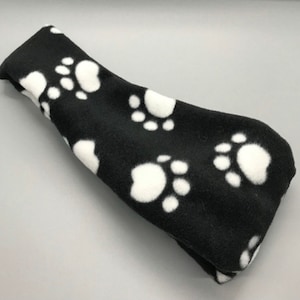 May include: Black fleece headband with white paw print design.