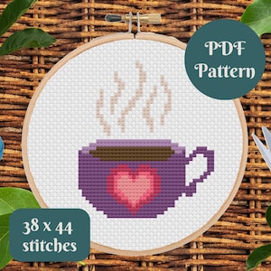 May include: A cross stitch pattern for a purple coffee mug with a heart and steam coming from the top. The pattern is 38 x 44 stitches and is available as a PDF download.