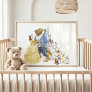 May include: A framed watercolor print of Belle and the Beast dancing, with a castle in the background. The print is displayed in a nursery setting, alongside a teddy bear. The artwork features soft colors and a whimsical style.