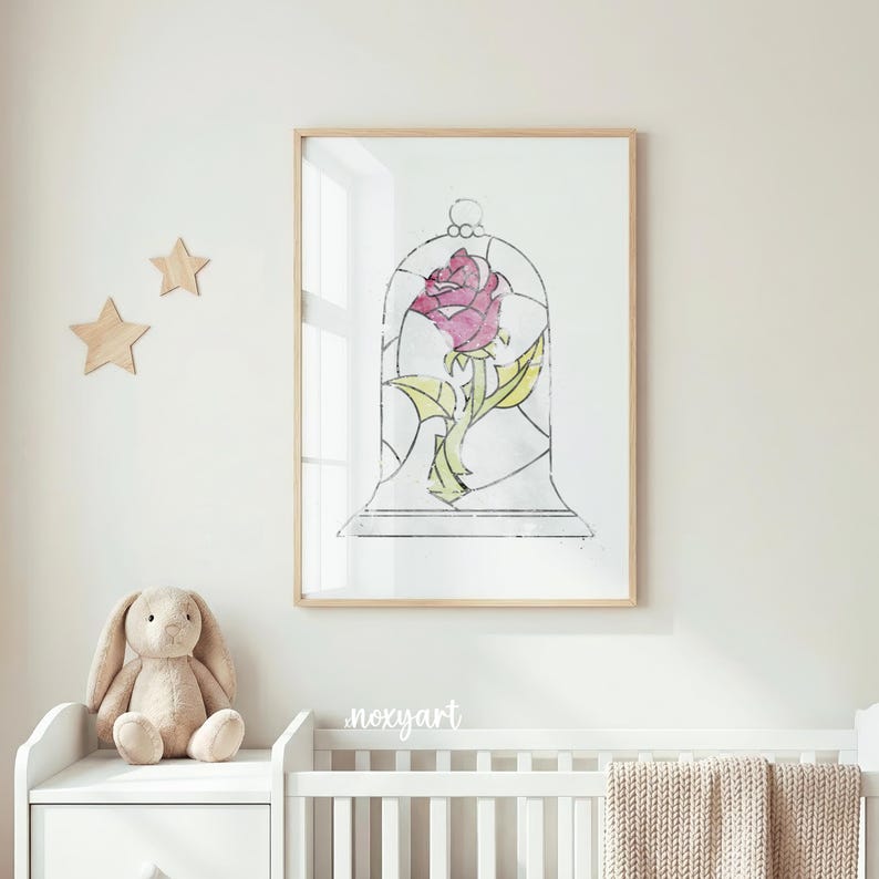 May include: A framed print featuring a pink rose inside a glass bell jar. The artwork has a stained-glass effect with green leaves and a light-colored wooden frame. The image is displayed in a nursery setting with a white crib and a stuffed bunny.