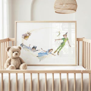 May include: A framed horizontal print featuring a watercolour illustration of Peter Pan, Wendy, John, and Michael Darling flying through the air with Tinker Bell, surrounded by a trail of golden pixie dust, displayed in a light wood frame.