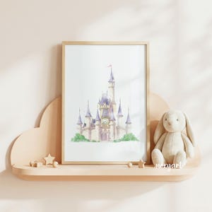 May include: A framed watercolor print of a castle with purple spires and a central clock face, displayed on a light-colored cloud-shaped shelf next to a plush beige rabbit toy and small wooden star and sphere decorations.