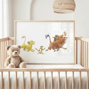 May include: A rectangular framed wall art print featuring a watercolor illustration of a yellow lion cub, a brown meerkat, and a brown warthog running. The artwork is displayed in a light wood frame resting inside a wooden crib next to a plush teddy bear.