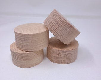 May include: Four unfinished wooden circles stacked on top of each other. The circles are made of light wood and have a smooth, rounded surface.
