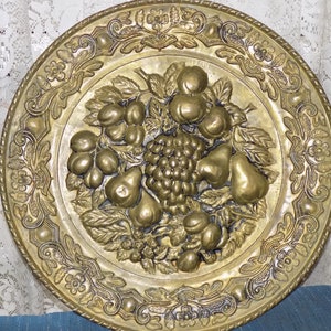 A Vintage Embossed Brass Wall Plate w/a Assorted Fruit Design. (16.5&quot;dia)  A Embossed Brass Platter w/a Fruit Decoration to Hang on The Wall