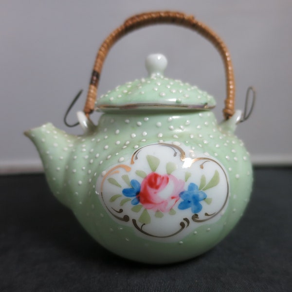 Vintage porcelain miniature teapot with woven wicker rattan handle floral hand painted green white