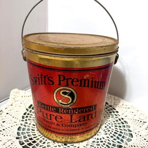 May include: Vintage Swift's Premium Pure Lard tin with a metal handle. The red and gold tin features the Swift & Company logo and text. The net weight is 3.6 kg.
