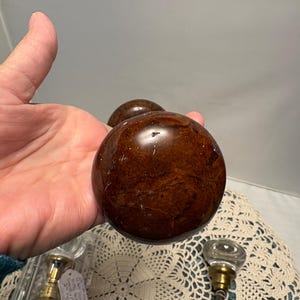 May include: A white ceramic mug with a black handle and the text "But First, Coffee" in a black, bold font. The mug is on a white surface. The mug is approximately 4 inches tall.