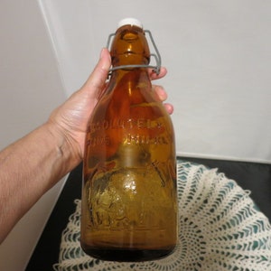 vintage bouteille de lait d&#39;un litre Amber Thatcher&#39;s Dairy avec vache à traire bouchon en porcelaine en relief