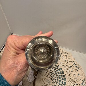 May include: A white ceramic mug with a black handle and the text "But First, Coffee" in a black, bold font. The mug is on a white surface. The mug is likely for hot beverages.