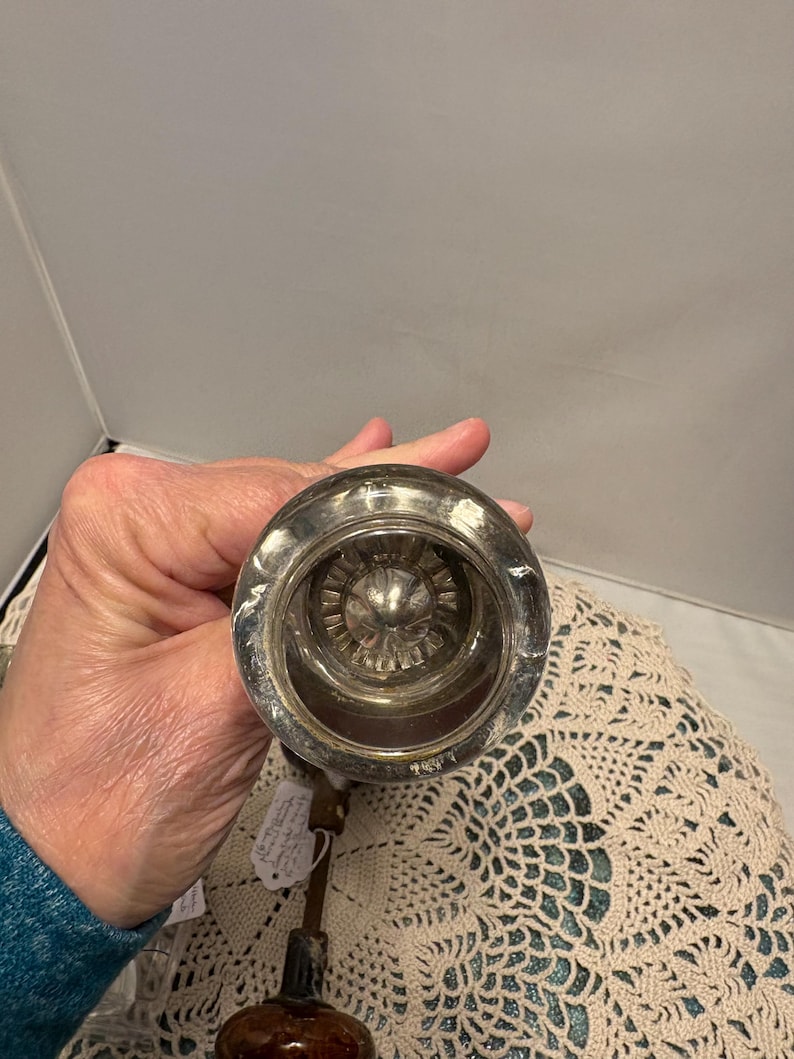 May include: A white ceramic mug with a black handle and the text "But First, Coffee" in a black, bold font. The mug is on a white surface. The mug is likely for hot beverages.