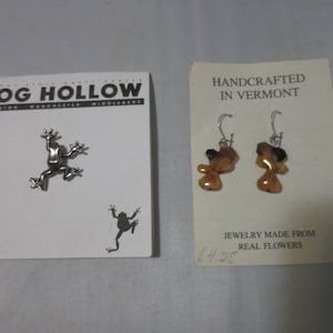 May include: A pair of earrings made from real flowers, with a brown and black color scheme. The earrings are handcrafted in Vermont and are displayed on a white card with the text "HANDCRAFTED IN VERMONT" and "JEWELRY MADE FROM REAL FLOWERS".